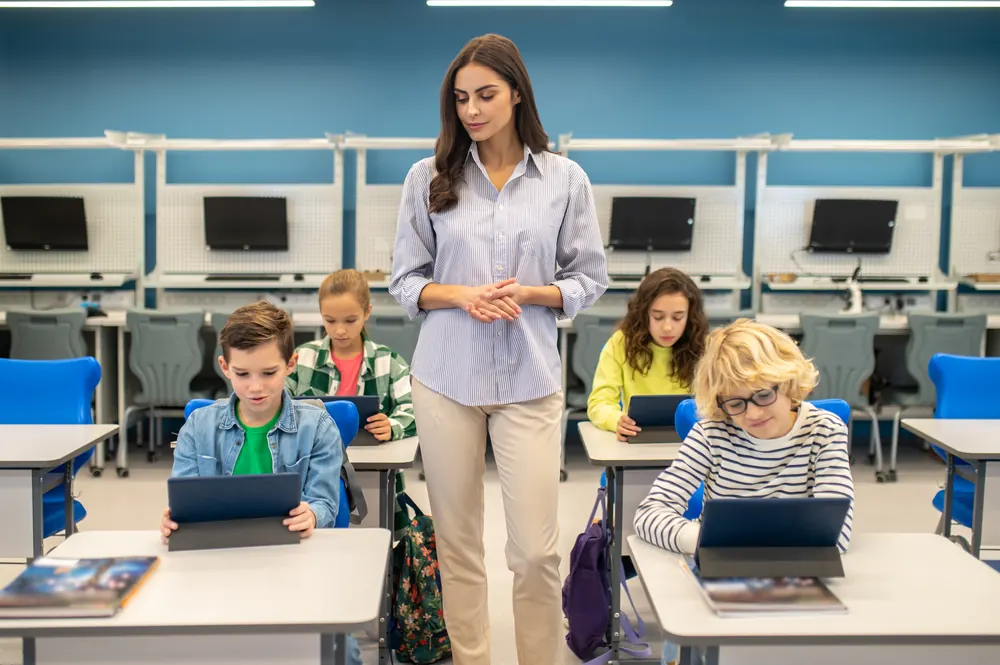 Professora com alunos usando tablets