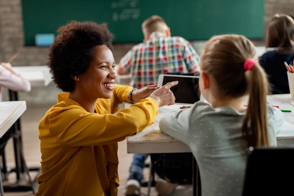 Professora e aluna com tablet em sala