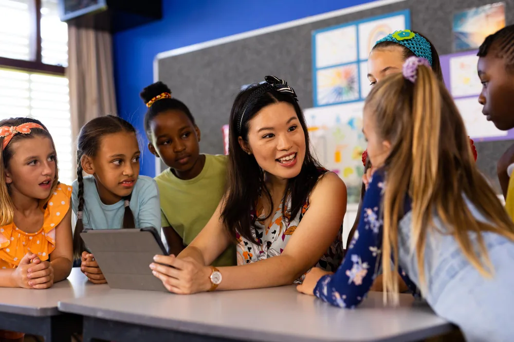 Professora com alunos usando tablet em sala de aula